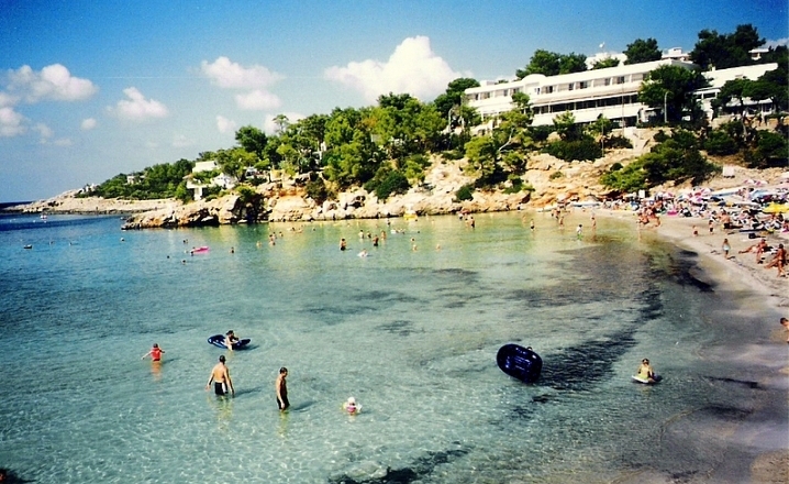 Visitors swimming on the beach of Portinatx 